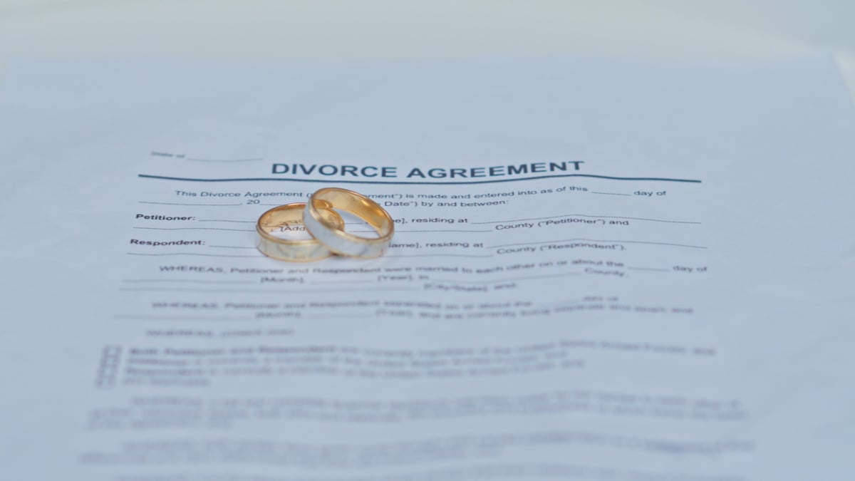 Divorce Agreement Document with Wedding Rings on Top